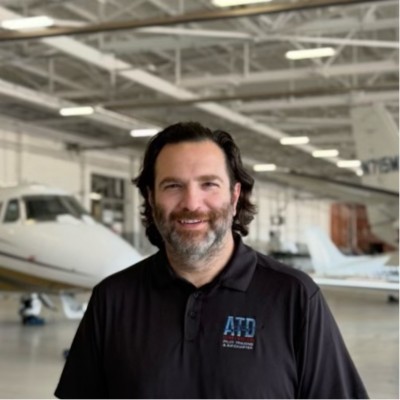 Lute Atieh in an aircraft hangar with an ATD Flight Systems aircraft